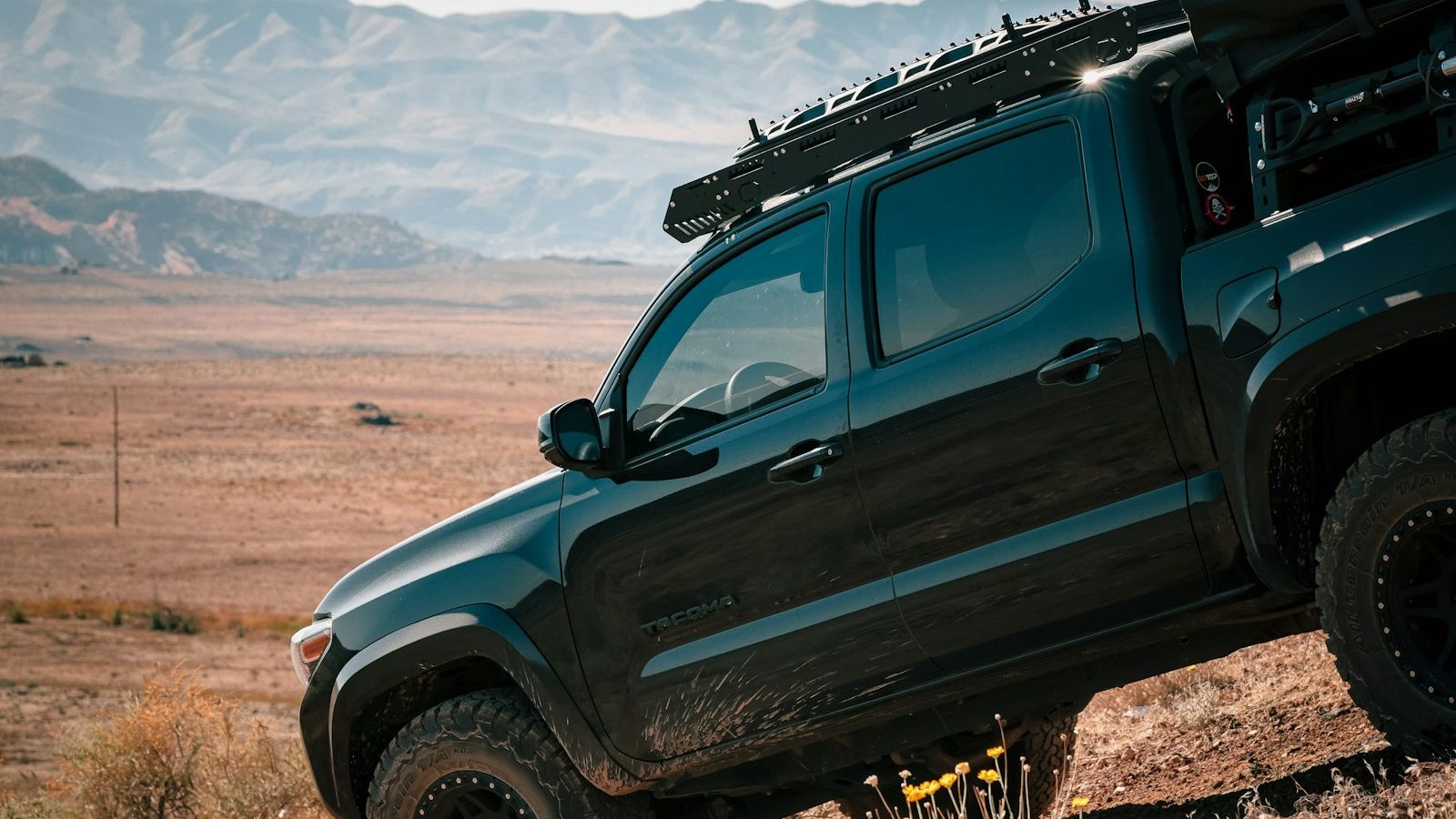 Toyota Tacoma with a roof rack climbing a steep desert slope