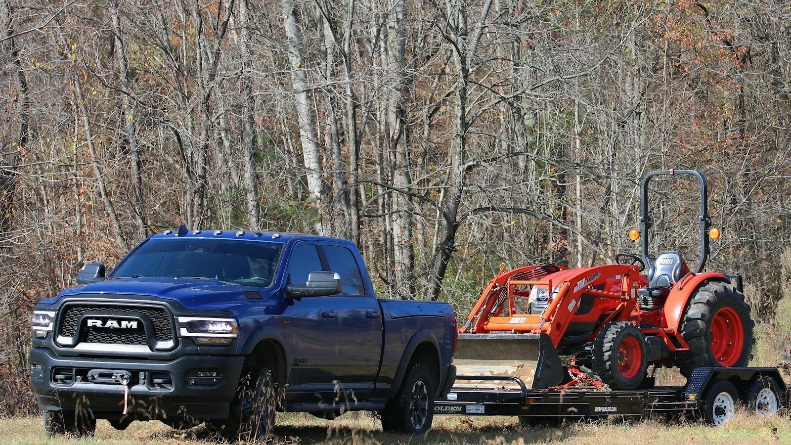 Ram heavy-duty pickup towing a tractor on a flatbed trailer